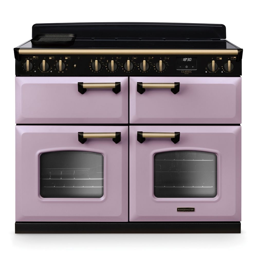 Classic Deluxe 110cm BC induction range cooker in heather with antique brass accents, featuring four ovens, six control knobs, and a sleek black top.