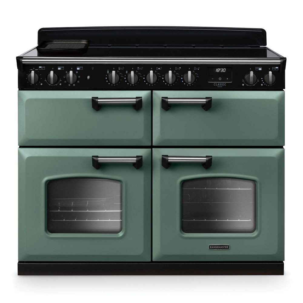 Classic Deluxe 110cm BC induction range cooker in mineral green with chrome accents, featuring four ovens, a black control panel, and multiple knobs for precise temperature control.
