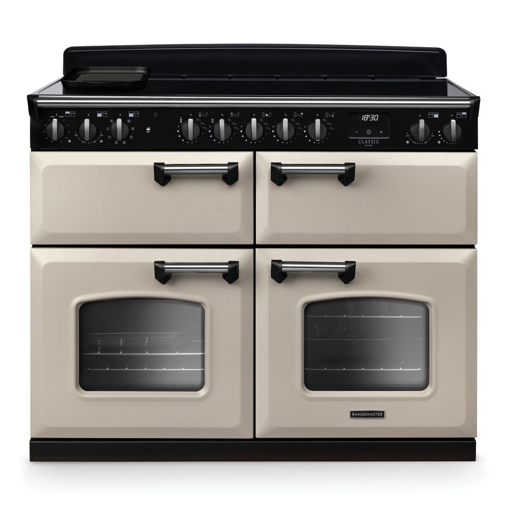 Classic Deluxe 110cm induction range cooker in pale cream and chrome, featuring four ovens, a sleek black control panel, and multiple knobs for precise cooking control.