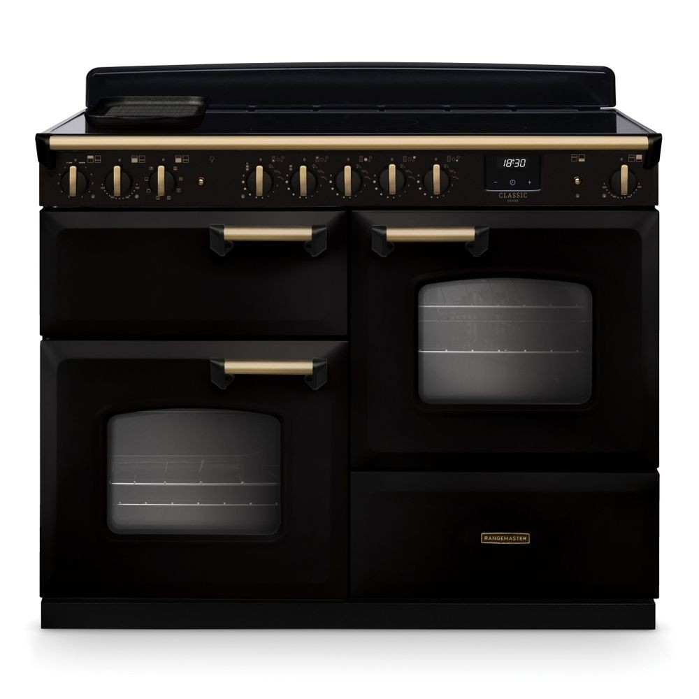 Classic Deluxe 110cm induction range cooker in black with antique brass accents, featuring multiple control knobs, two ovens, and a sleek glass top.