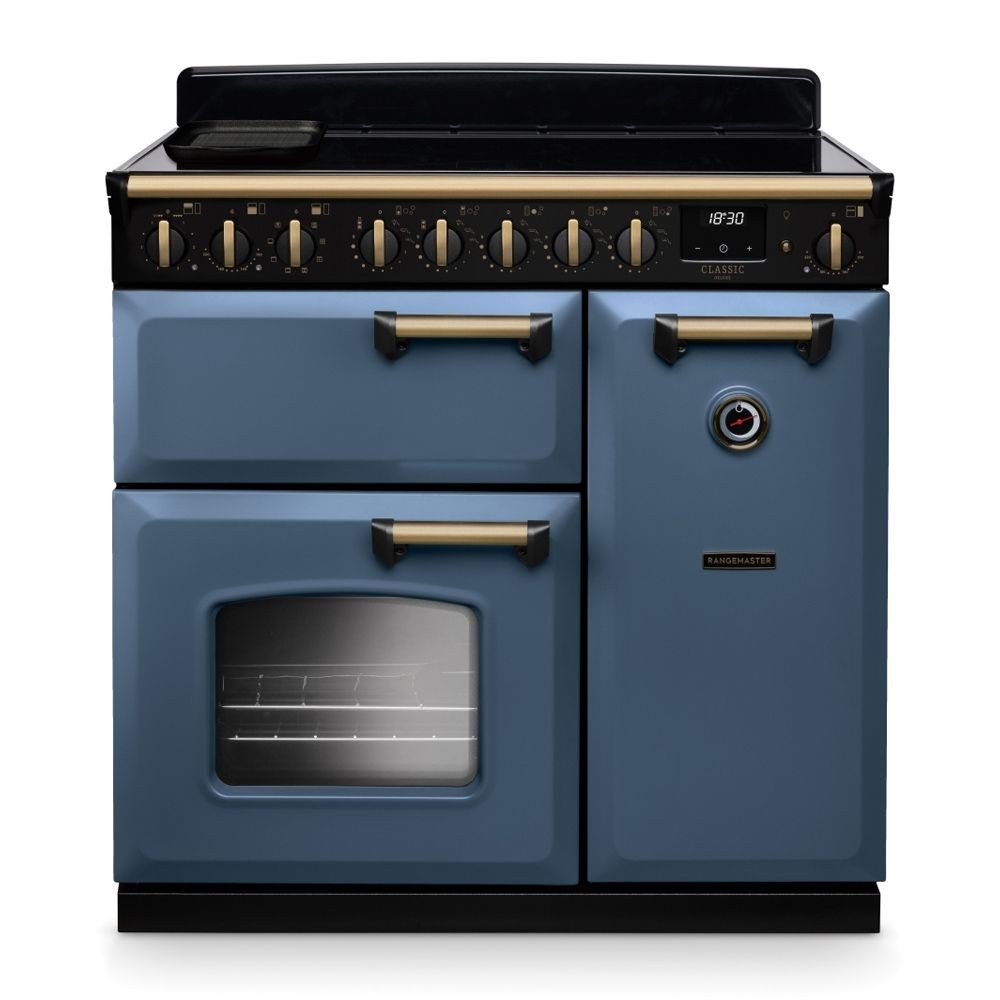 Classic Deluxe 90cm induction range cooker in stone blue with antique brass accents, featuring five control knobs, a large oven door, and a sleek black top surface.