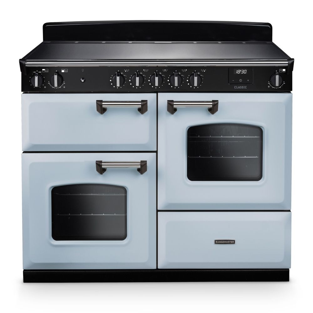 Classic OC 110cm induction cooker in misty blue and chrome, featuring a sleek black cooktop, dual ovens with glass windows, and prominent control knobs.