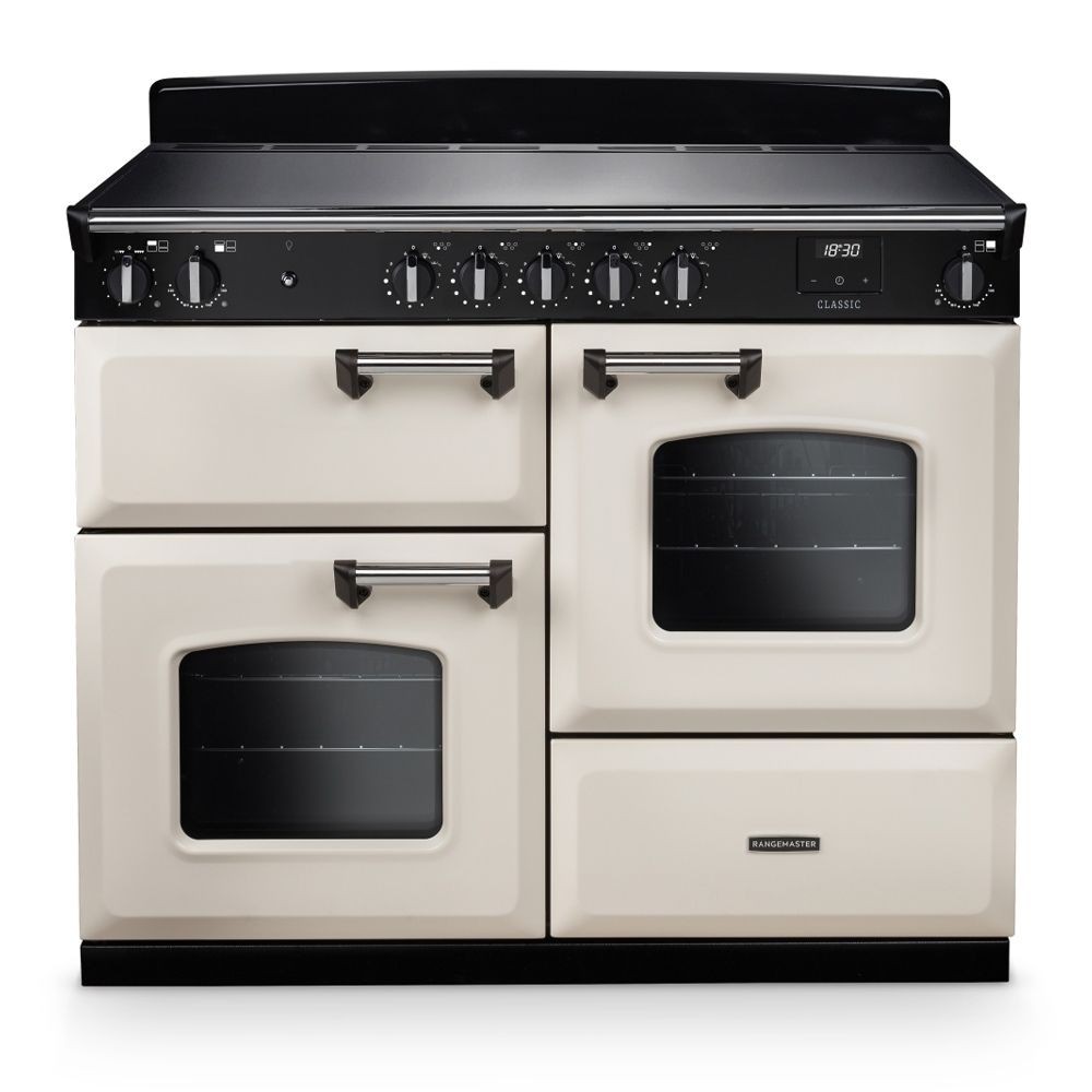 Classic OC 110cm induction cooker in pale cream and chrome, featuring a sleek black cooktop, two ovens with glass windows, and chrome knobs for precise temperature control.