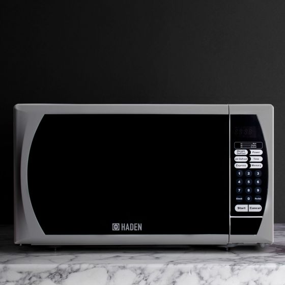 Silver 20L microwave by Haden featuring a sleek black front panel, digital display, and control buttons on the right side, set against a marble countertop.