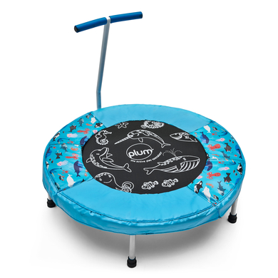 Round toddler trampoline with a blue padded edge featuring ocean-themed designs, a black jumping surface with "plum" logo, and a sturdy blue handle for support.