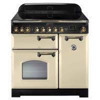 Classic 90cm induction range cooker in cream with brass trim, featuring a sleek black control panel, multiple knobs, a large oven window, and a stylish design.