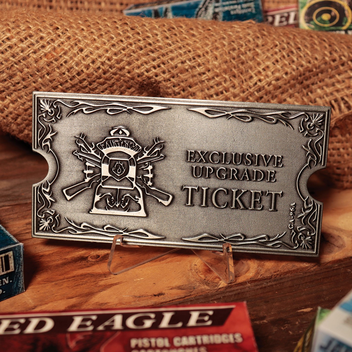 Metallic silver upgrade ticket featuring intricate designs, including weapons and a shield, with the text "EXCLUSIVE UPGRADE TICKET" prominently displayed.