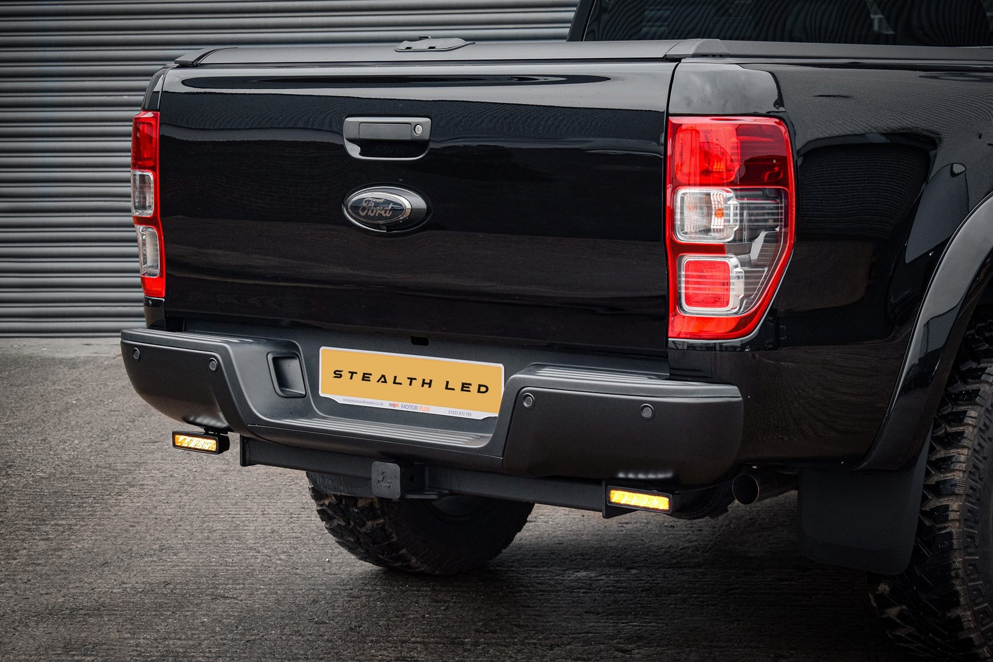 Black Ford Ranger T8 rear with a Stealth LED integration kit featuring twin 6" flashing luminous LED lights, showcasing bright amber illumination and a sleek design.