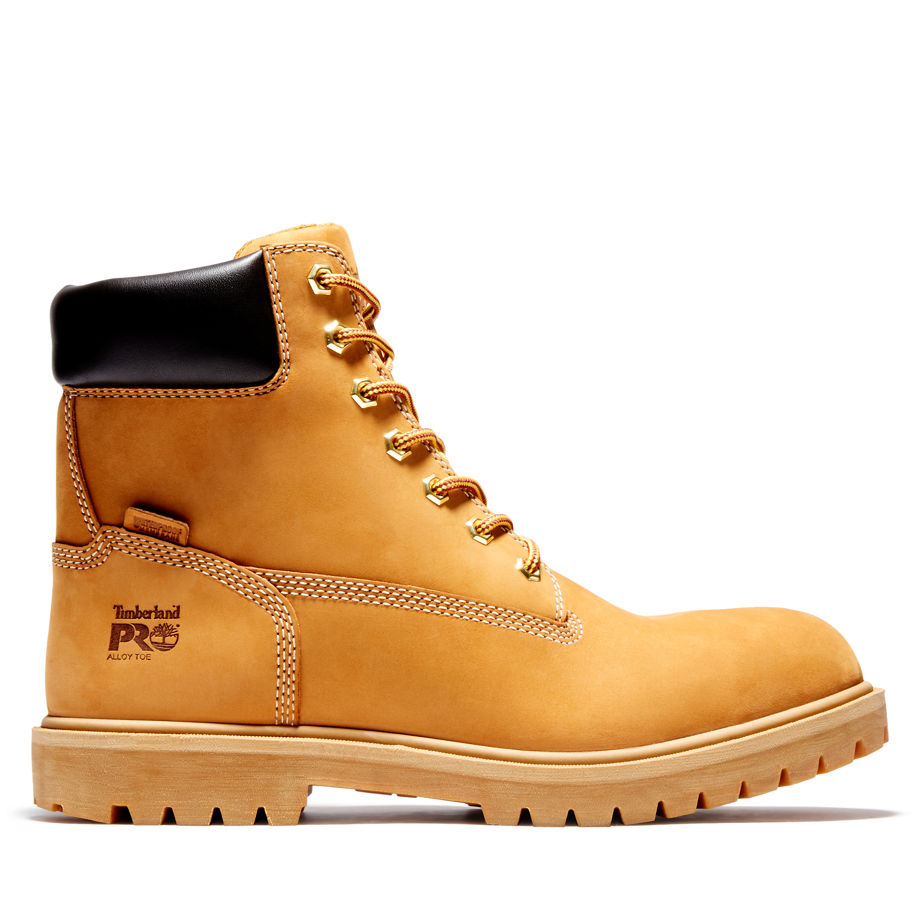 Wheat-colored leather safety boot with black collar, metal eyelets, and thick rubber sole, featuring Timberland Pro logo on the side.