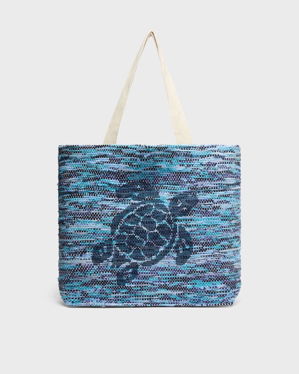 Large canvas beach bag in shades of blue with a turtle design, featuring sturdy beige handles, perfect for summer outings.
