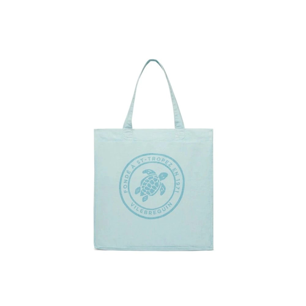 Light blue linen beach bag with a circular turtle logo in the center, featuring two sturdy handles and a solid design, ideal for beach outings.