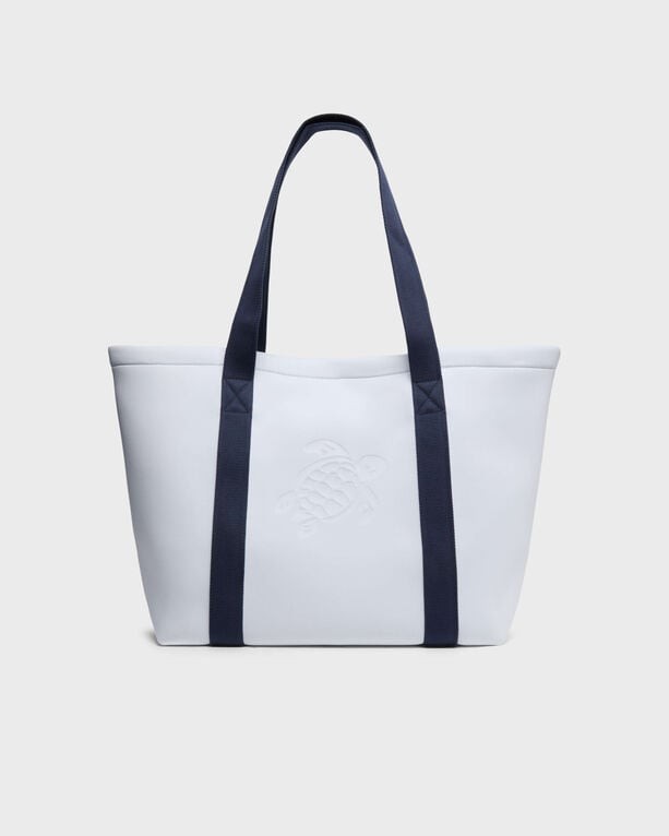 White neoprene beach bag featuring a textured turtle logo, navy blue handles, and a spacious design, ideal for beach outings.