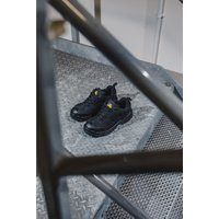 Black Amblers Safety vegan-friendly shoes, size 7, with reinforced toe and slip-resistant sole on metal stairs.