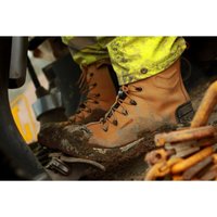 Brown leather Amblers safety boots with black laces and reinforced toe, worn and muddy, size 7.