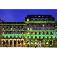 Manchester Portland hotel with illuminated green facade, arched windows, and classic architecture at night.