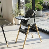 Grey Tutti Bambini highchair Nova with wooden legs, adjustable tray, and padded seat in a modern kitchen setting.