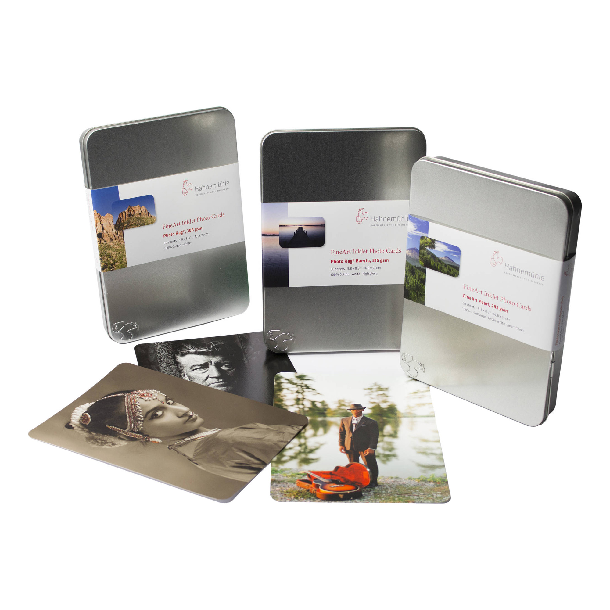 Four metallic tins containing Hahnemühle Photo Rag A5 sheets, showcasing high-quality, textured paper in a natural white color, each tin labeled with sample images.