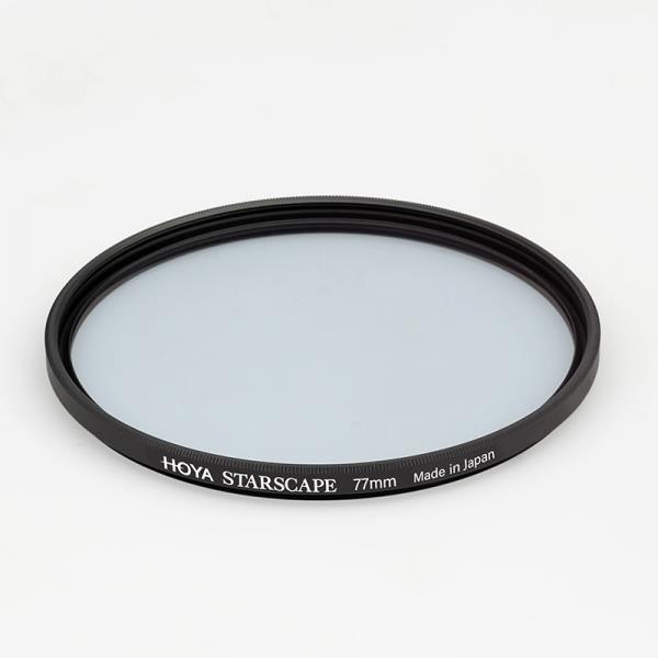Circular Hoya STARSCAPE filter with a black metal rim and a translucent white glass surface, labeled with "HOYA STARSCAPE 77mm Made in Japan."