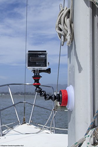 Black and red flexible camera mounting accessory with a suction cup base, attached to a boat's railing, holding a GoPro camera against a scenic water backdrop.