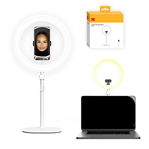 White LED ring light on a stand, featuring a smartphone holder, illuminating a face, with a box labeled Kodak in the background, designed for selfies and videos.