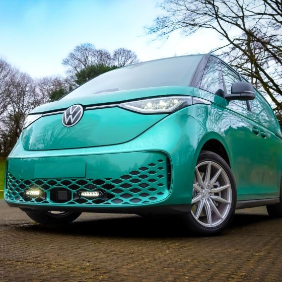 Lazer Lamps Grille Integration Kit featuring sleek Linear 6 lamps, mounted on a turquoise Volkswagen vehicle, showcasing a modern design with a distinctive grille pattern.