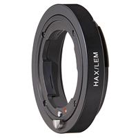 Black metal Novoflex HAX/LEM camera lens adapter with a smooth circular design, featuring engraved white text and a red alignment dot for precise attachment.