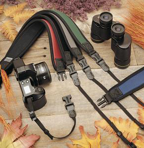 Navy OpTech Classic Strap made of durable material, featuring adjustable clips, alongside a camera and binoculars on a rustic wooden surface with autumn leaves.