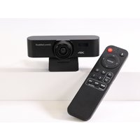 Black HuddleCamHD MiniTrack 4K Pro webcam with lens in center, mounted on base, paired with black remote control.