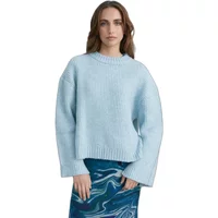 Light blue cashmere jumper with ribbed crew neck and long sleeves, worn by a woman over a blue patterned skirt.