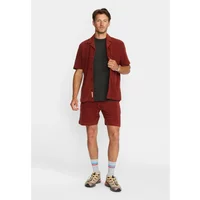 Red short-sleeve terry cloth shirt with button front, worn over a black tee, paired with matching shorts.
