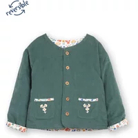 Green girl's jacket with wooden buttons, floral trim, and reversible design featuring fairy flower pattern.