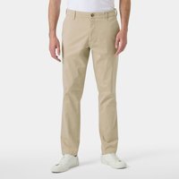 Beige Helly Hansen men's Bryggen chino pants, straight fit, button closure, belt loops, worn by model with white shoes.