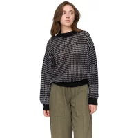 Houndstooth pattern jumper, black and white, long sleeves, ribbed cuffs and hem, worn by woman with brown hair.