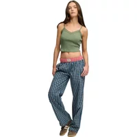 Green lace trim vest with spaghetti straps, worn by a model, paired with blue plaid pants.