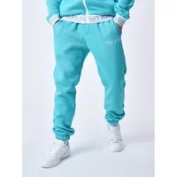 Turquoise joggers with logoed elastic waistband, Project X Paris branding on thigh, paired with white sneakers.