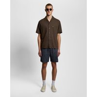 Navy linen blend shorts with vertical stripes, worn by a model with a brown shirt and sunglasses.
