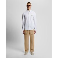 Brown Lyle & Scott men's straight leg linen blend trousers with side pockets, worn with a white shirt and sunglasses.