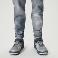 Dreich grey clipless cycling shoes with black strap, textured sole, and subtle logo on side, worn with grey camo pants.