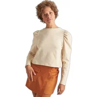 Cream puff sleeve jumper with long sleeves, worn by a woman, paired with an orange skirt.