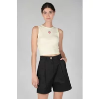 Black single-button women's shorts with pleats, worn by a model in a sleeveless cream top.