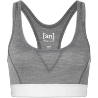 Gray Super.Natural sports bra with racerback design and white elastic band.