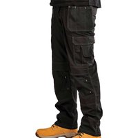 Black Stanley Iowa work trousers with multiple pockets and reinforced knees, worn with yellow boots.