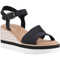 Black TOMS Darya sandal with ankle strap, buckle, and espadrille wedge heel on white platform sole.