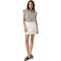Black and white patterned blouse with cap sleeves and a collar, paired with a white skirt.