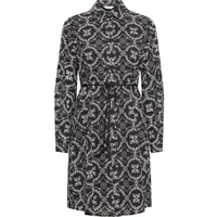Black and white patterned women's dress with long sleeves, button-up front, and a tie waist belt.