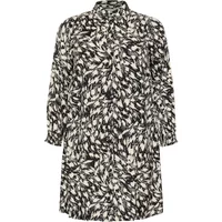 Black and white patterned women's dress KAFFE Curve Jamia with long sleeves and a collared neckline.