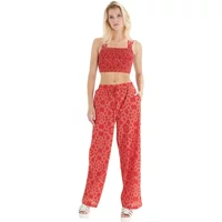 Red geometric print trousers with wide legs and elastic waistband, paired with matching crop top.