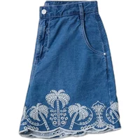 Blue denim shorts with white embroidered palm tree pattern and side pockets.