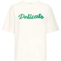 Women's white T-shirt by b.young with "Delicate" in green cursive on the front.
