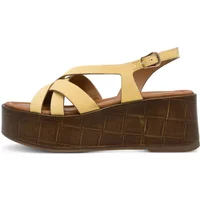 Beige women's wedge sandals with crisscross straps and brown textured platform.